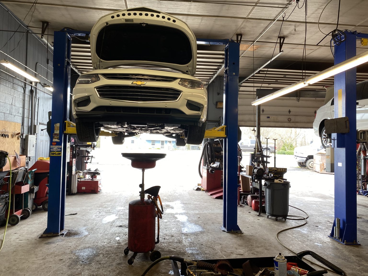 Inside the shop at Total Automotive in Cumming, GA, with a car up on the lift and both bays in use